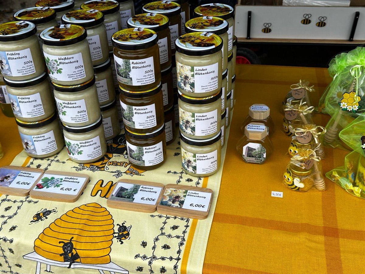 Voll assortierte Honiggläser mit Etiketten und Holztäfelchen am Bienenstand